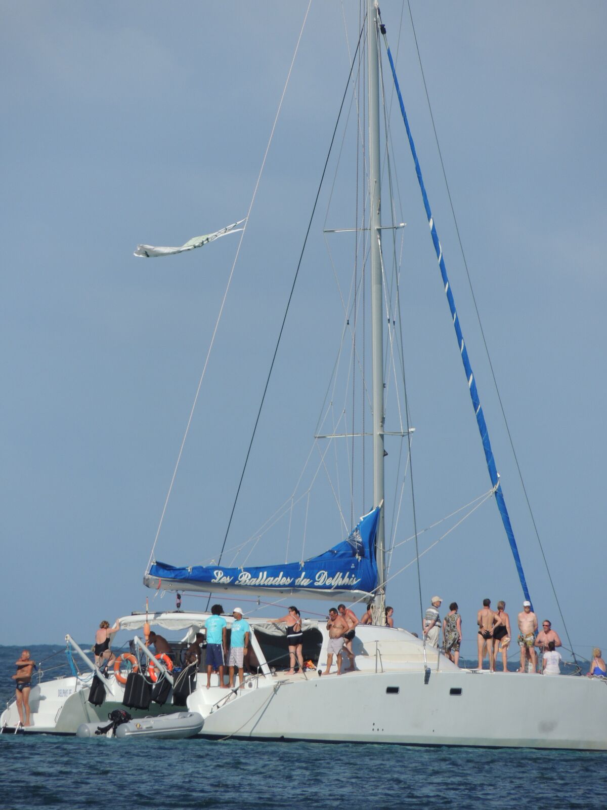 Un voilier à voile bleue, portant l’inscription « Los Ballades del Delfhix » sur sa coque, était amarré dans des eaux d’un bleu limpide.