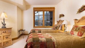 A bedroom with two beds, a dresser, a window, and a lamp. - Elegant Condo in Beaver Creek (Edwards)