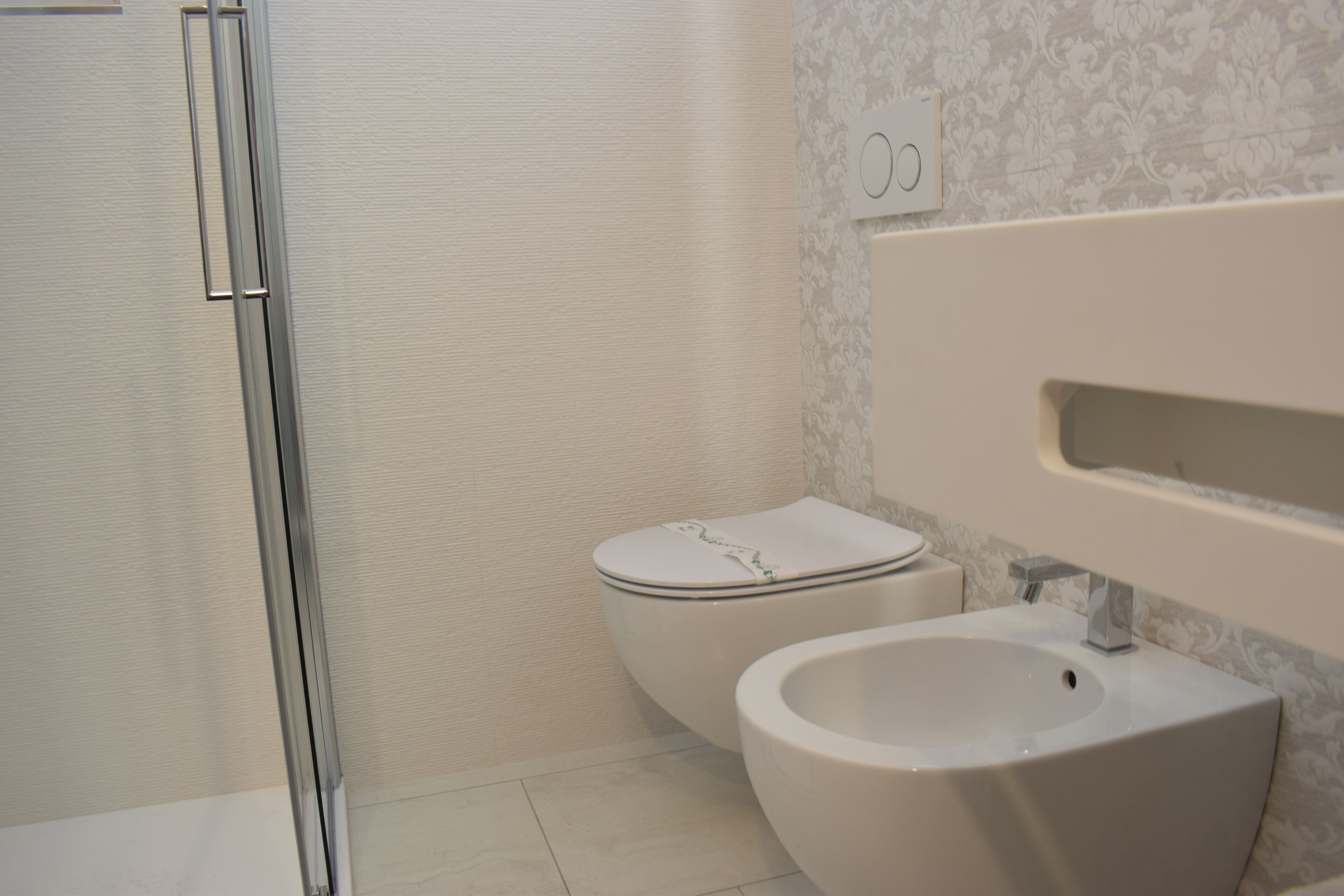 Un baño con inodoro, bidé y zona de ducha.