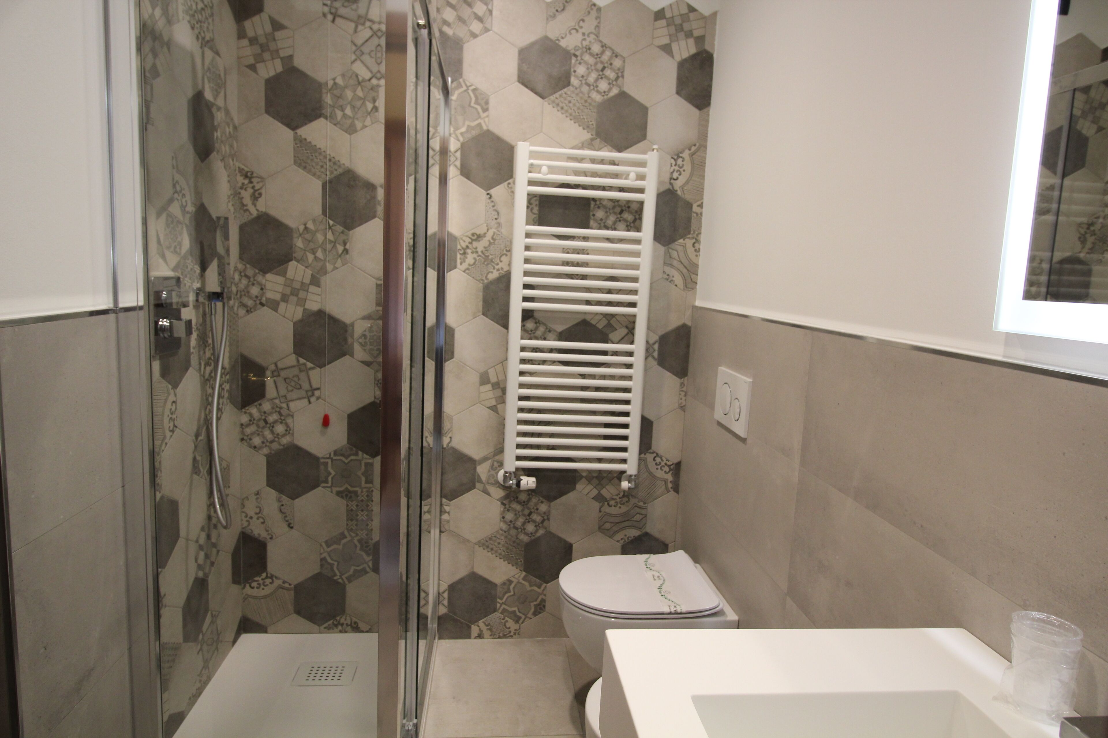 Une salle de bain avec douche, toilettes et lavabo.