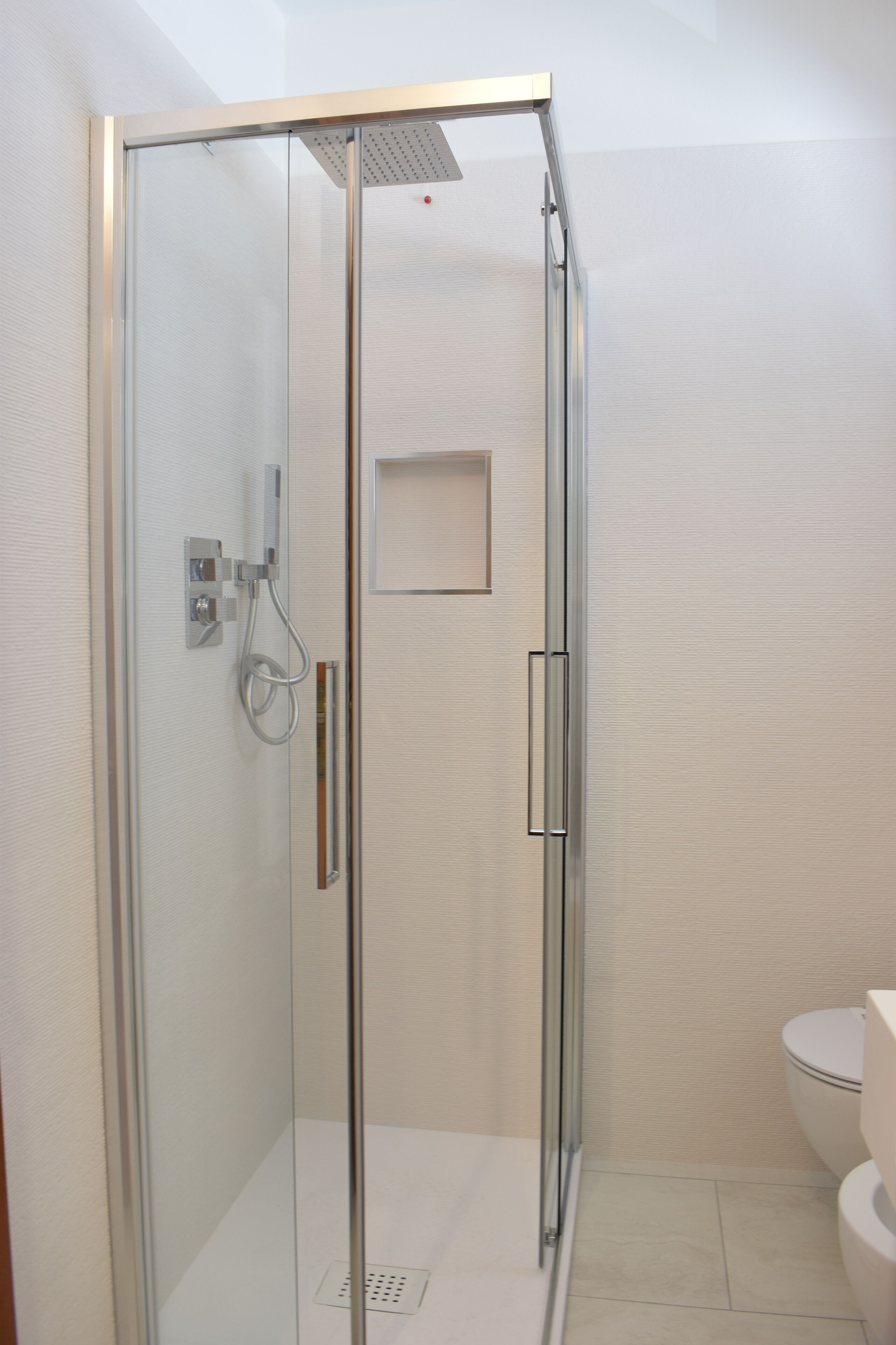 Ein modernes Badezimmer mit Duschkabine, Toilette und Waschbecken.