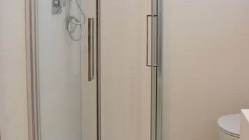 Ein modernes Badezimmer mit Duschkabine, Toilette und Waschbecken.