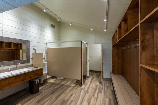 A modern bathroom with a wooden vanity, a large mirror, and a shower area. - Mountain & Golf Course Views, Close to Shuttle Stop for Easy Resort Access! (Keystone)