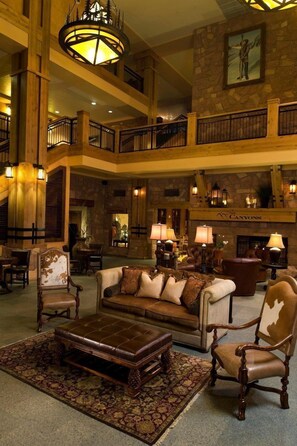 Step into a classic setting with a grand staircase, ornate chandelier, and cozy seating areas.