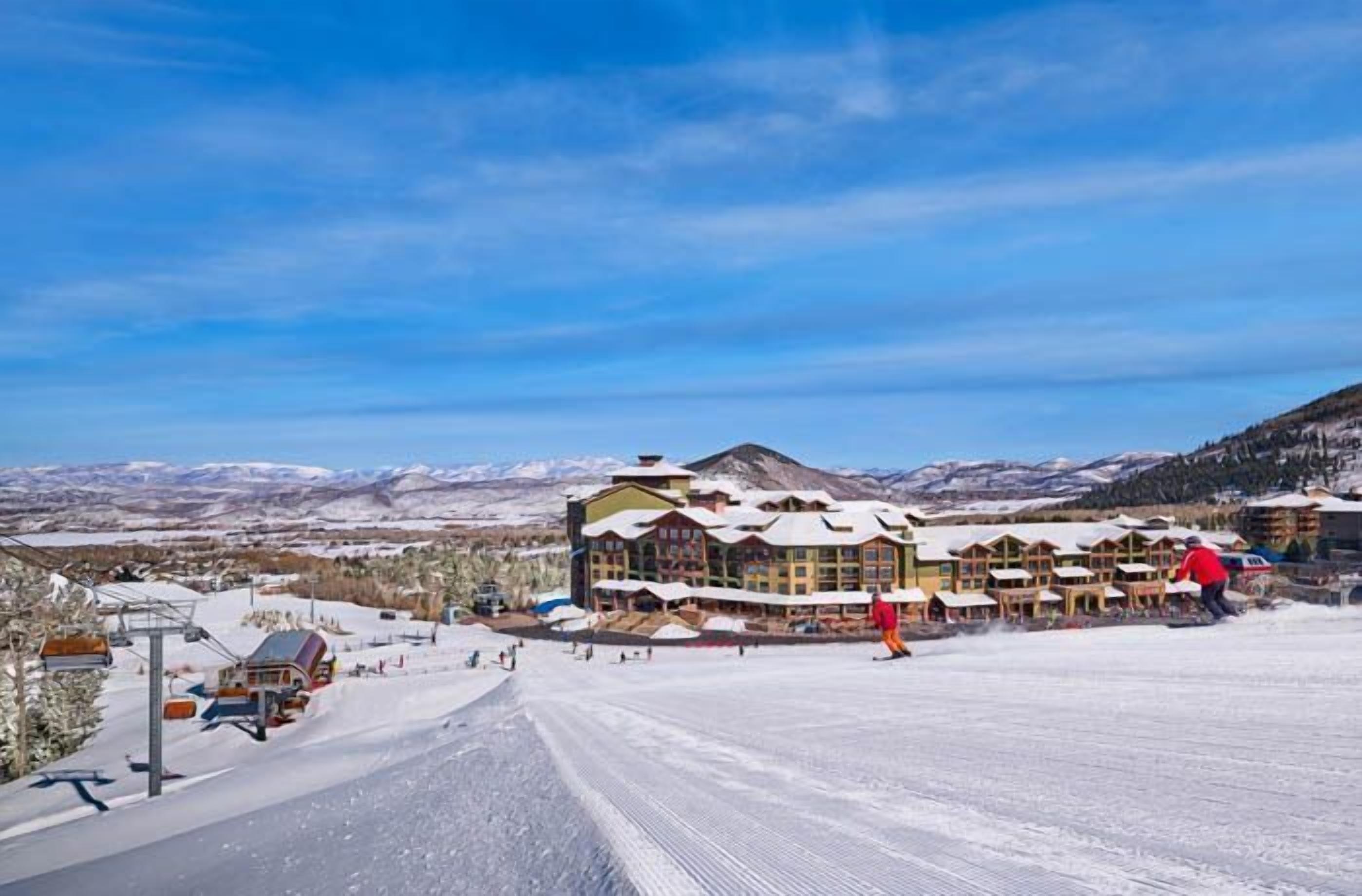Une station de ski dotée d’un chalet comprenant plusieurs bâtiments, d’un télésiège et offrant un paysage enneigé.