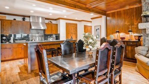 Una cocina amplia con armarios de madera, una isla grande y una zona de comedor con una mesa y sillas.