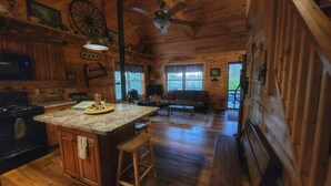 A cabin interior with a kitchen, dining area, and living room. - Upscale Cozy Cabin in the Woods, LETCHWORTH, Stony Brook Parks, Wineries (Dalton)