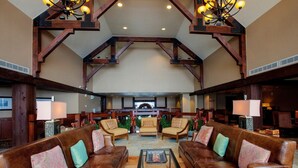 A spacious lobby with high ceilings, wooden beams, leather sofas, and a central coffee table. - Ski-In Alpine Condo + Balcony | Great Location (Breckenridge)