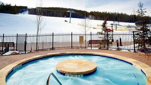 A pool with a wooden deck and a metal fence. - Ski-In Alpine Condo + Balcony | Great Location (Breckenridge)