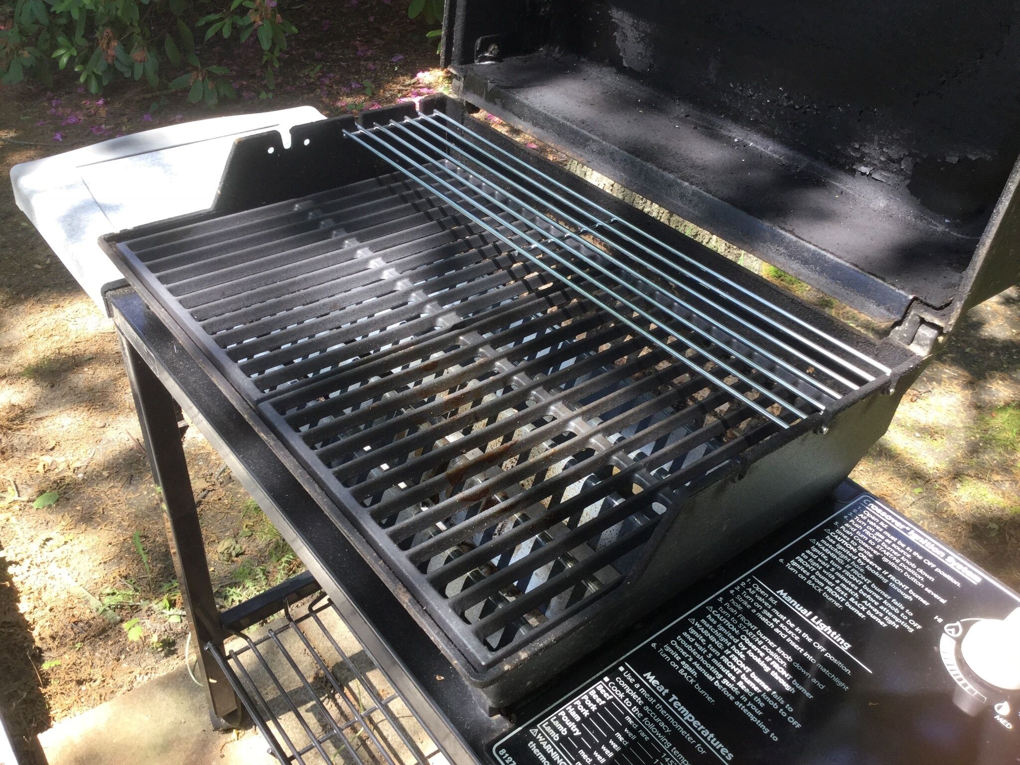 An open grill with a metal grate and a control panel with instructions.