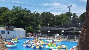 Una piscina con gente en embarcaciones de colores.