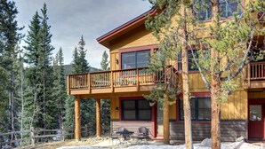 A two-story lodge with a balcony, surrounded by trees. - Cozy Mountain Getaway for 4 with Amazing Amenities (Dillon)