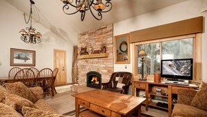 Una sala de estar acogedora con chimenea, muebles de madera y televisión.