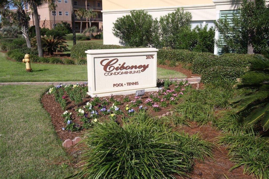 Schild für Ciboney Condominiums mit Schwimmbad und Tennisplatz.