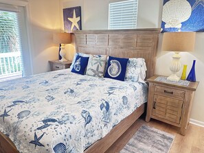 A bedroom with a bed, nightstands, a wooden headboard, and decorative pillows.