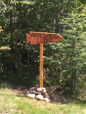 A wooden signpost with the text "Arrowhead Lodge" pointing to the right.