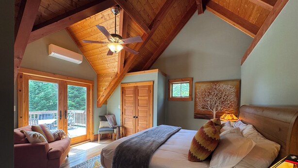 A bedroom with a bed, a ceiling fan, a window, and a door. -  Sleeps 20! Minutes to Main St & Lakes HotTub PoolTable Pingpong FirePit AC (Lake Placid)