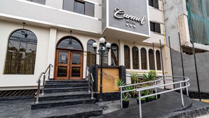 A hotel entrance with a marble staircase, a wooden door, and a sign that reads "Carnel Hotel". - Hotel Carmel (Lima)