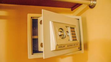 A safe with a dial and keypad, mounted on a yellow wall.
