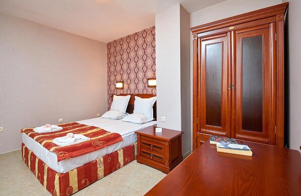 A hotel room with a bed, bedside table, and a wardrobe. - Karolina (Nessebar)