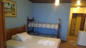 A room with a bunk bed, a single bed, a small refrigerator, and a painting on the wall. - Pousada Tony Montana (Angra dos Reis)
