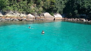 A clear turquoise pool surrounded by rocky terrain and dense greenery. - Pousada Tony Montana (Angra dos Reis)