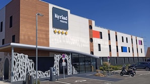A modern building with a sign reading "Kyriad Prestige" and a five-star rating. - Kyriad Prestige Hôtel and Spa, Amiens Nord (Poulainville)