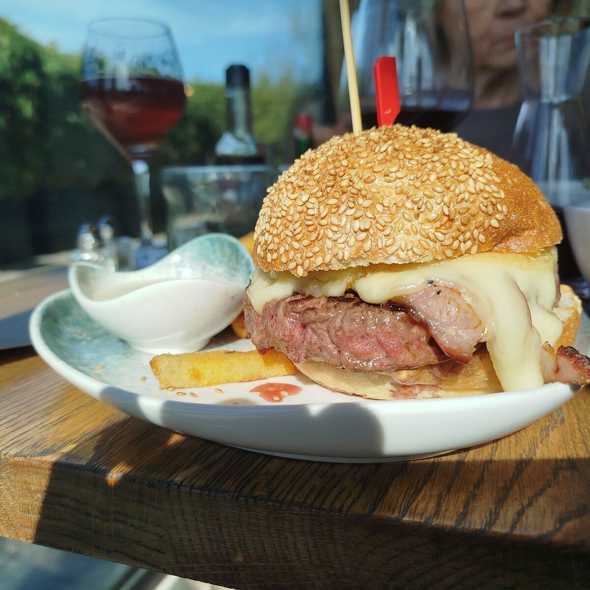Un plato con un sándwich, papas fritas y una bebida.