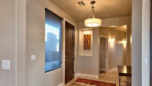 A modern interior with a curved hallway, wooden flooring, a large window, and a ceiling light fixture. - Fish Rock Retreat Holiday home 3 (St. George)