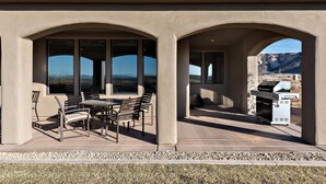 An outdoor patio with a table and chairs, a grill, and a view of mountains. - Fish Rock Retreat Holiday home 3 (St. George)