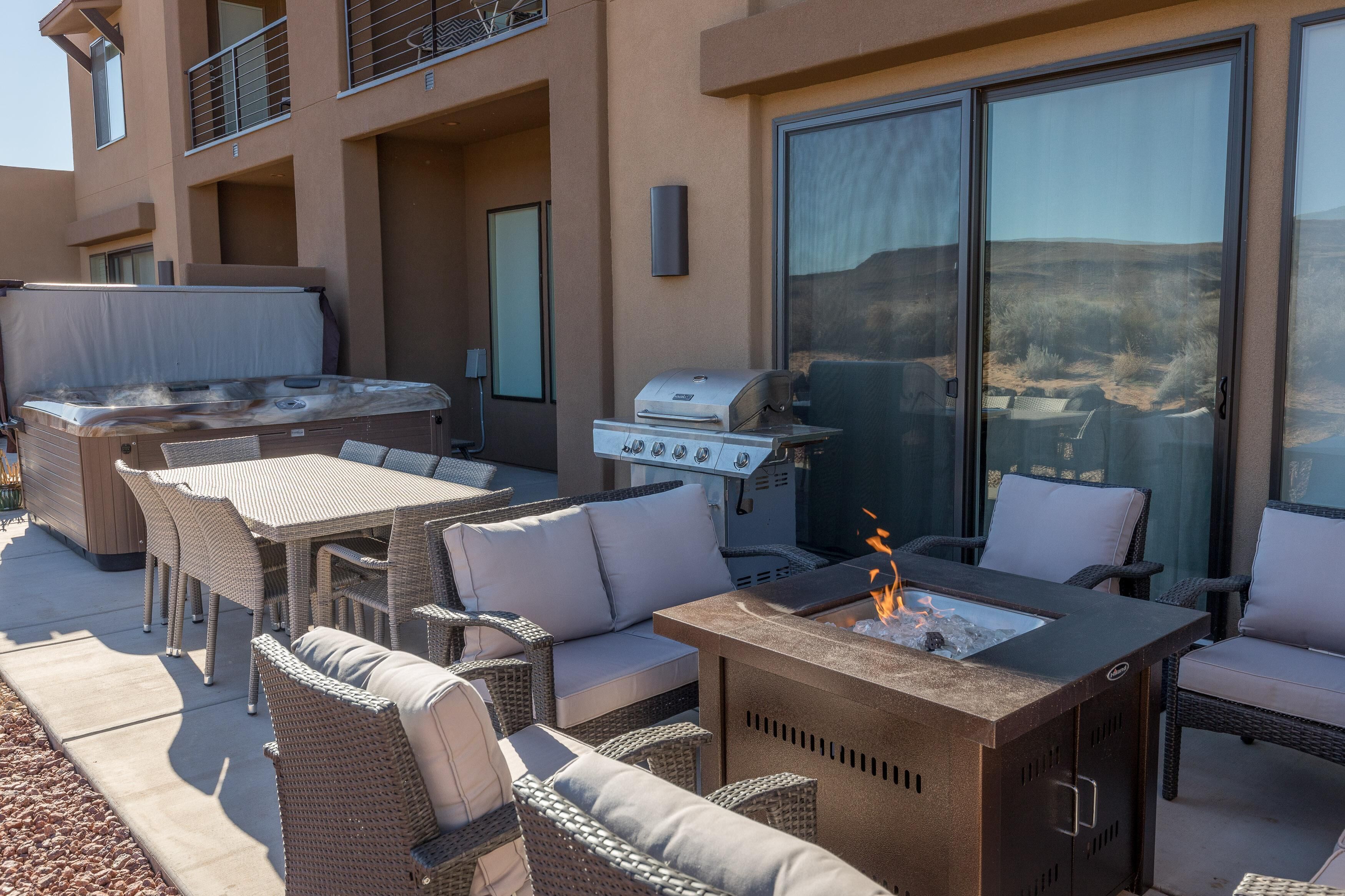 An outdoor patio with wicker furniture, a grill, and a fire pit.