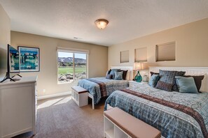 A bedroom with two beds, a desk, a bench, a window with a view, and artwork on the wall. - I Could Live Here (St. George)