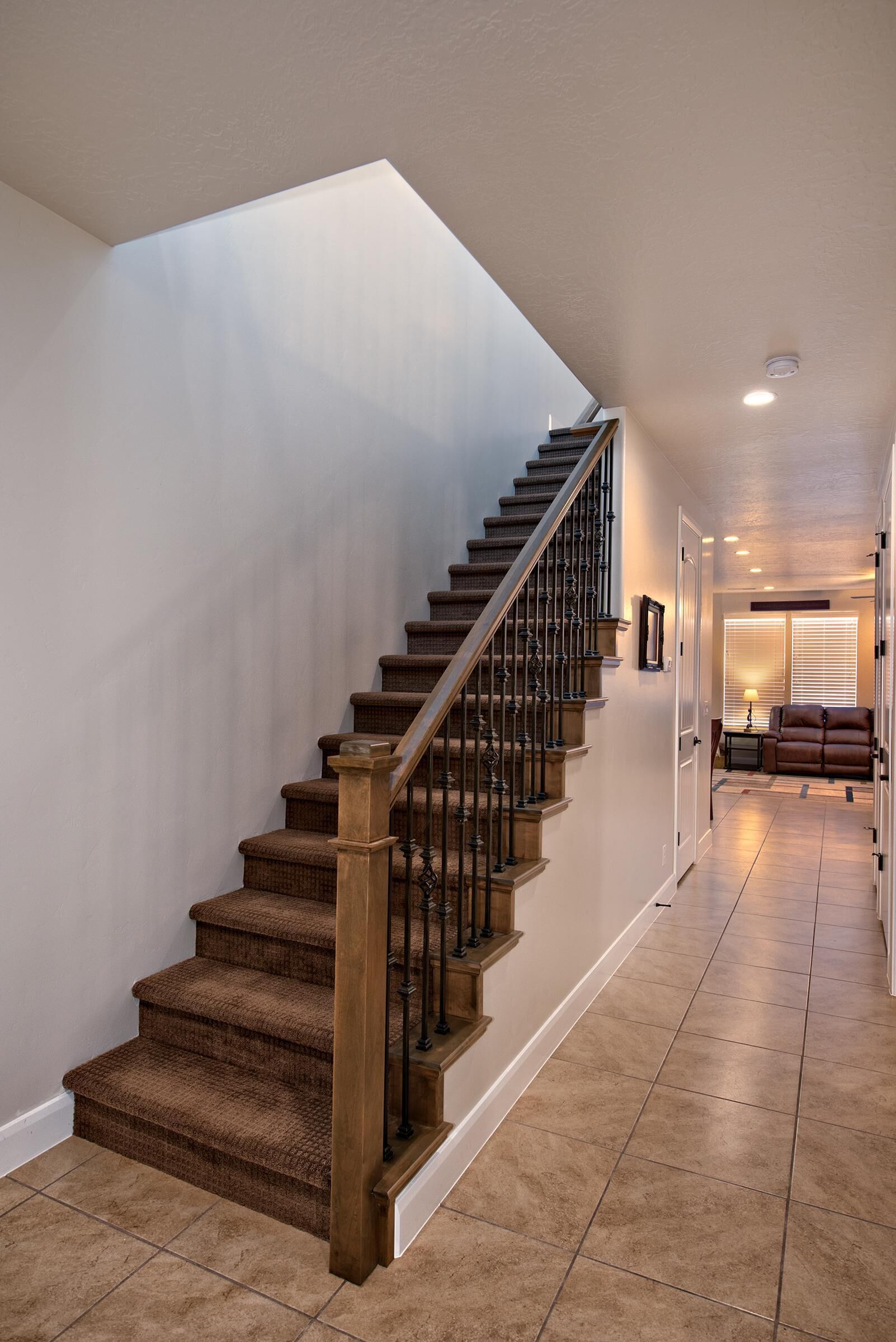 A staircase with wooden steps and metal railings leading to a landing.