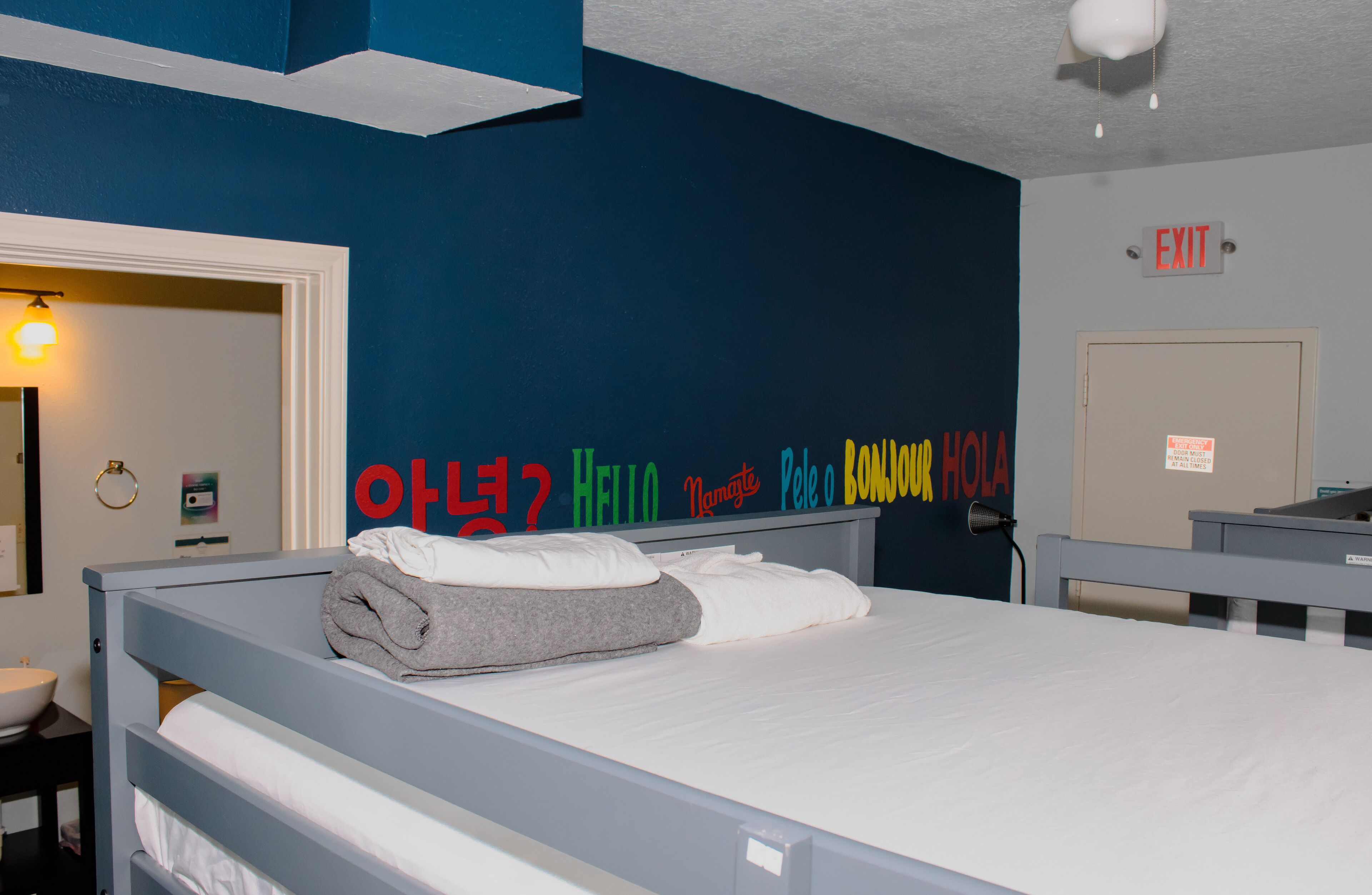 Una habitación de hotel con una cama, un lavamanos y una puerta.