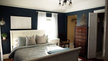 A bedroom with a bed, a dresser, a chair, and a wardrobe.