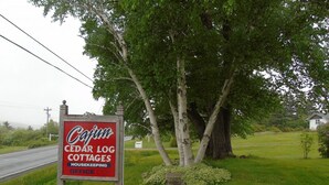 Un panneau indiquant l’emplacement des « Cedar Log Cottages » et signalant le bureau des services d’entretien.