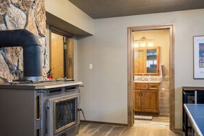 Une cuisine avec un mur en pierre, un poêle et un meuble en bois.