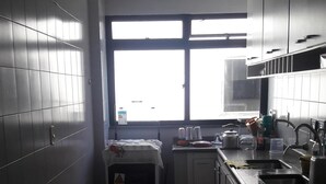 Une petite cuisine avec une fenêtre, un évier et une cuisinière.