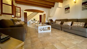 Un vaste salon doté d’un haut plafond, d’un escalier et d’une cheminée.