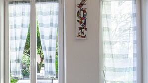 A dining table with a floral tablecloth, a bowl of fruit, a bottle of juice, and a croissant. - Casa Mary - For 4 people, in centre, 5 minutes from beach and station to Cinque Terre (Levanto)