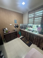 A compact kitchen with a gas stove, sink, and a window with blinds.