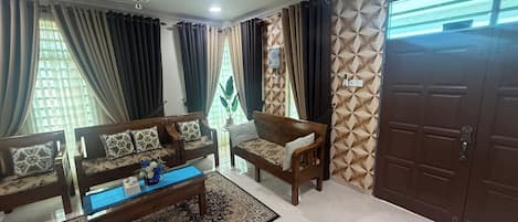 A living room with a sofa set, a coffee table, and a patterned rug.