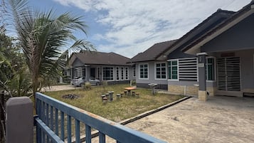 A residential area with a gated entrance, a paved courtyard, and a building with a tiled roof.