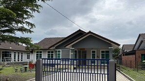 Uma entrada fechada para um prédio residencial com telhado cinza e paredes brancas.