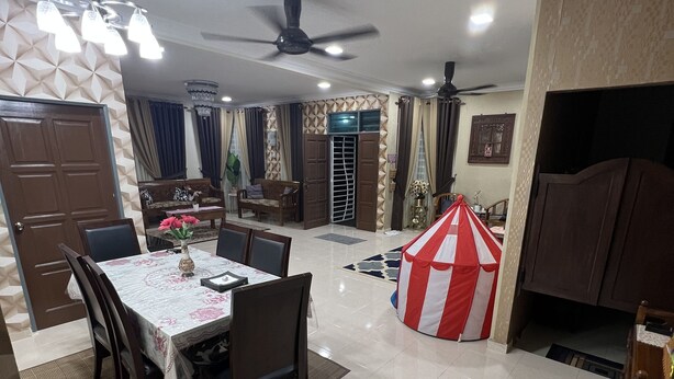 Ampla sala de estar com mesa de jantar, cadeiras, ventilador de teto e uma tenda de brincadeira listrada em vermelho e branco.