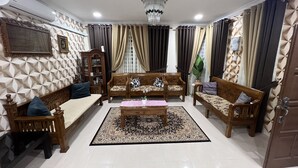 Uma sala de estar com sofá, mesa de centro e tapete estampado.