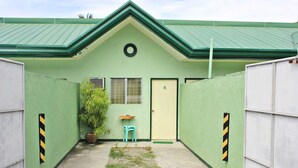 A small, single-story building with a green roof and a door marked with the number 6. - Bulalo Mangrove Inn (Calapan)