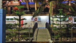 A two-story building with a wooden bridge leading to a gated entrance. - Eduardo's Resort (Calapan)