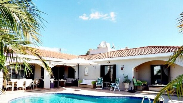 A poolside area with a clear blue pool, outdoor seating, and a building with a tiled roof. - Stunning, Stylish and Spacious 3 Bedroom Villa with a Private Pool (Emba)