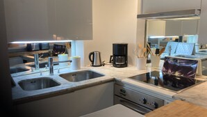 Una cocina moderna con electrodomésticos de acero inoxidable, un lavamanos doble y un horno empotrado.